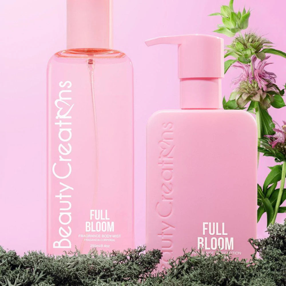 Two pink bottles labeled 'Full Bloom' by Beauty Creations on a pink background with greenery.